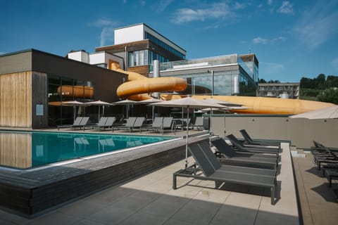 Außenpool mit Liegen und Rutsche am Familienhotel Schreinerhof