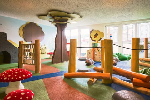 Indoor-Spielwelt Biberland mit Holzbäumen, Balancierbalken und Fliegenpilzen