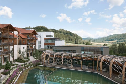 Blick über das Familienhotel Schreinerhof mit Naturbad und den Hügeln des Bayerischen Waldes