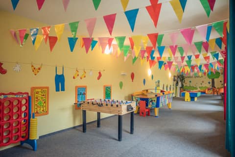 Bunte Indoor-Spielhalle mit Bobbycar-Bahn und Wimpelketten